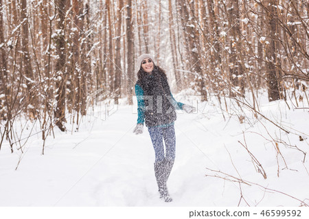 Young pretty woman throwing snow in the air in winter holidays Young pretty woman throwing snow in the air in winter holidays 46599592