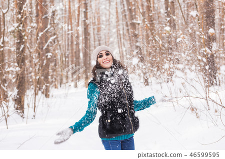Young pretty woman throwing snow in the air in winter holidays 46599595