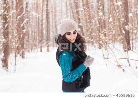Beautiful young woman walking in the winter snowy nature Beautiful young woman walking in the winter snowy nature 46599636