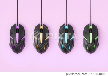 Black computer mouses hang on pink background Black computer mouses hang on pink background 46603003