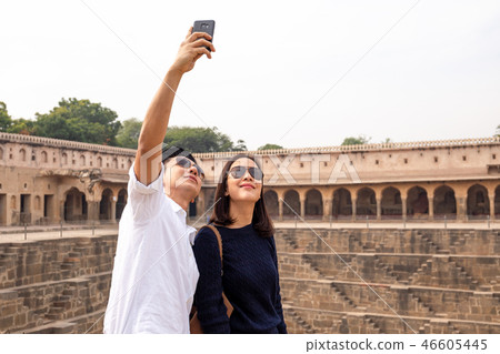 Asian couple happy in love taking selfie photo on Chand Baori stepwell in india. Asian couple happy in love taking selfie photo on Chand Baori stepwell in india. 46605445