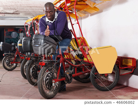 African-American man bikecab driver standing near rickshaw cycle African-American man bikecab driver standing near rickshaw cycle 46606802