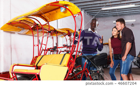 Pedicab driver negotiating with couple Pedicab driver negotiating with couple 46607204