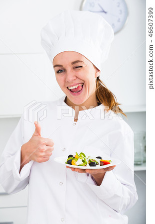 Girl cook shows plate of salad Girl cook shows plate of salad 46607399