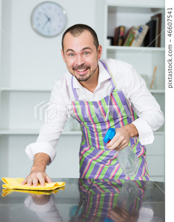 Young man in apron cleaning table 46607541