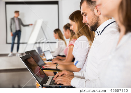 Side view of young people with laptops Side view of young people with laptops 46607550