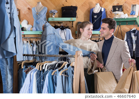 Young female with male are looking on jeans shirt for her Young female with male are looking on jeans shirt for her 46607640