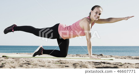 Woman exercising yoga at sea beach Woman exercising yoga at sea beach 46607771