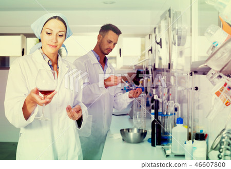 Woman winery expert in white coat checking quality of wine 46607800