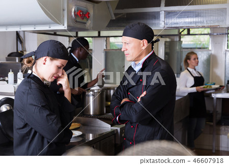 Exasperated chef scolding female employee 46607918