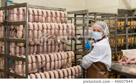 Female carrying sausages on racks Female carrying sausages on racks 46607944