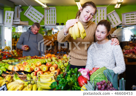 girl with mother choosing fresh ripe fruits 46608453
