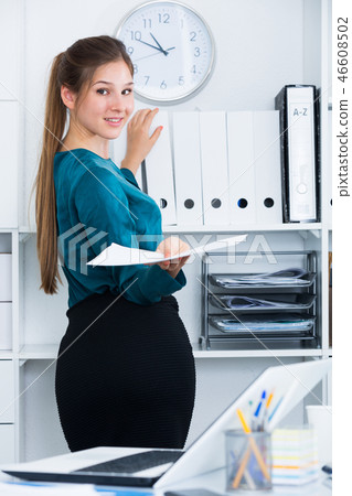 Female entrepreneur looking for documents on shelves 46608502