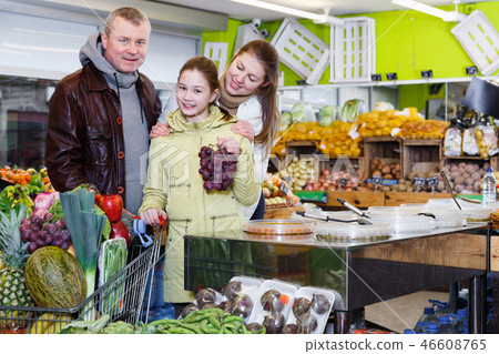 Friendly family with shopping cart in greengrocery 46608765