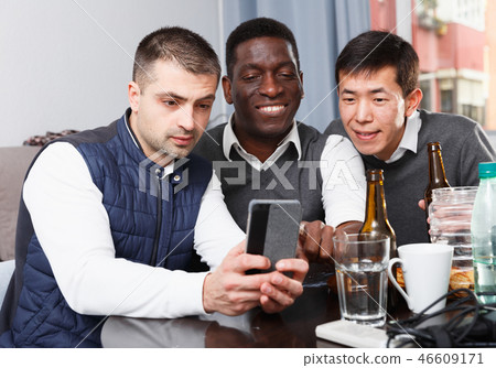 Three happy men with phone 46609171