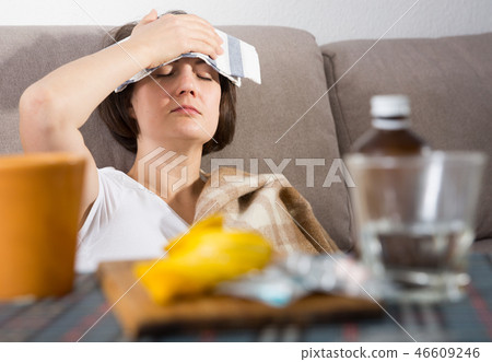 Sick woman lying on couch 46609246