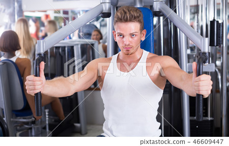 serious young man training upper body using fly machine serious young man training upper body using fly machine 46609447