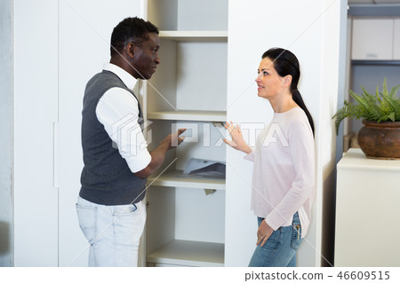 Smiling couple is choosing new cabinet Smiling couple is choosing new cabinet 46609515