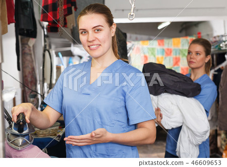 Happy girl ironing clothes at dry cleaning Happy girl ironing clothes at dry cleaning 46609653