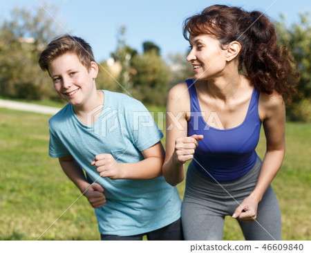 Woman and boy running outdoors Woman and boy running outdoors 46609840