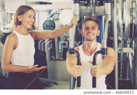 Man using pec deck gym machinery 46609913