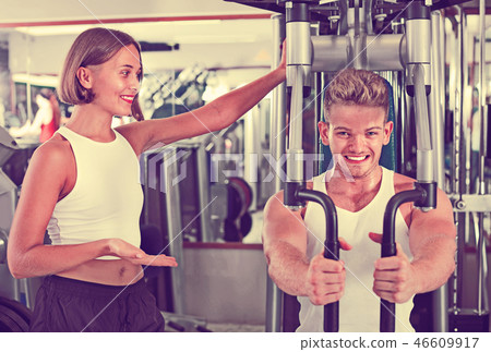 Female coach assisting man using fly machine 46609917