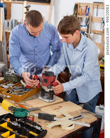 Family of two working with wood plank in workshop Family of two working with wood plank in workshop 46610063