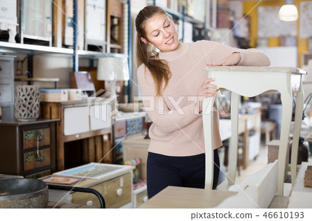 Girl customer choosing bedside in the furniture store Girl customer choosing bedside in the furniture store 46610193