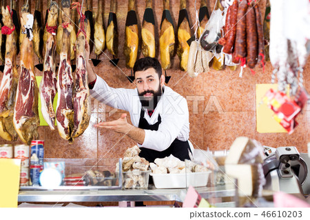 Male shop assistant demonstrating jamon 46610203