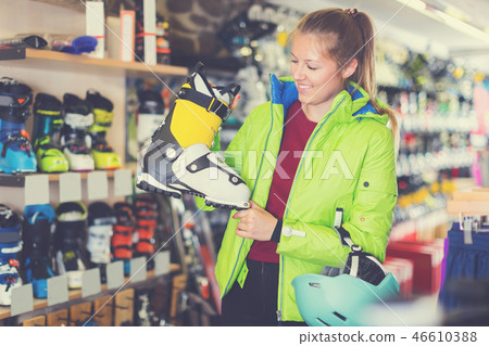 Client female in skiing equipment is choosing boots for skiing 46610388