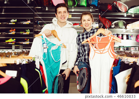 Female with male are choosing new T-shirt for tennis for him in the speciality store. 46610833
