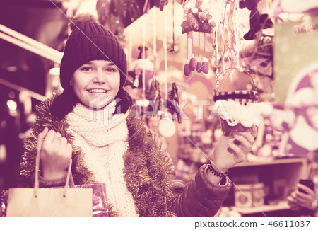 girl choosing Christmas decoration at market girl choosing Christmas decoration at market 46611037