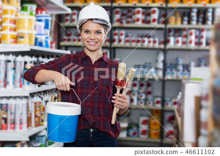 Woman is standing with paint and brushes 46611102