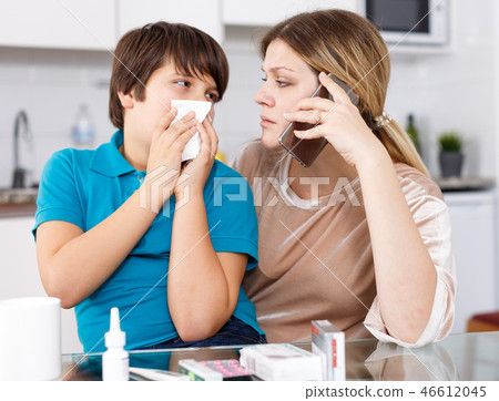Mother calling doctor, son sneezing 46612045
