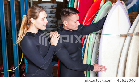 Couple choosing surf equipment 46612046