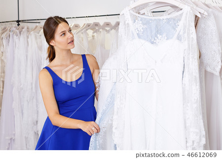 Woman holding wedding dress and choosing Woman holding wedding dress and choosing 46612069