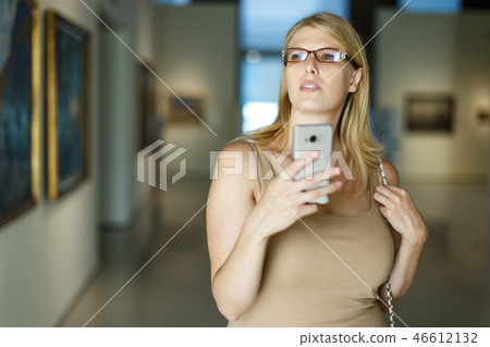 Woman taking photo in museum Woman taking photo in museum 46612132