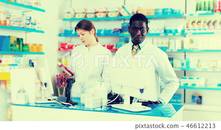 Two pharmacists working behind counter Two pharmacists working behind counter 46612213