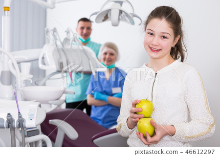 Happy girl with apples in dental clinic 46612297