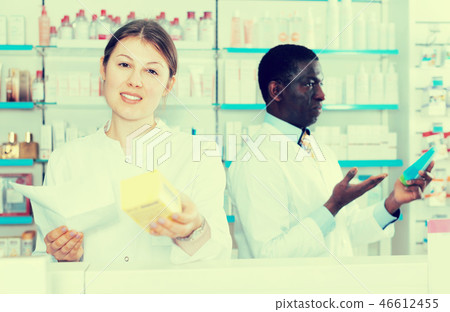 Female pharmaceutist showing medicines in pharmacy Female pharmaceutist showing medicines in pharmacy 46612455
