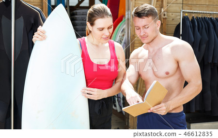 Girl discussing surf rental with man Girl discussing surf rental with man 46612835