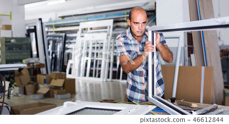 Man is checking quality of work on assembling plastic windows Man is checking quality of work on assembling plastic windows 46612844