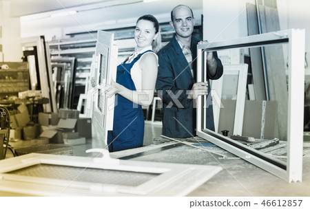 Foreman explaining plastic windows assembly process to young female worker 46612857