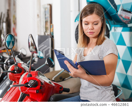 Woman is shopping and choosing new motobike 46612861
