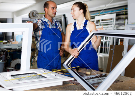 Female assembler of windows consulting with master 46612862