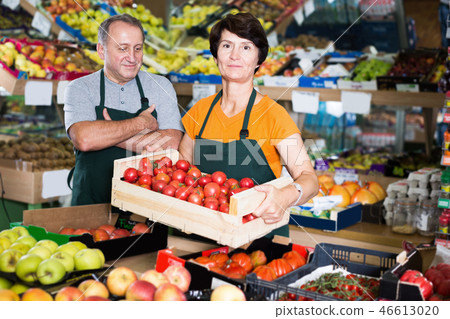 Happy couple sellers is standing with box with tomatos Happy couple sellers is standing with box with tomatos 46613020