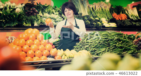 Portrait of adult female selling fruits and vegetables 46613022
