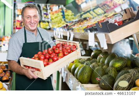 Smiling male employee showing natural tomatos Smiling male employee showing natural tomatos 46613107