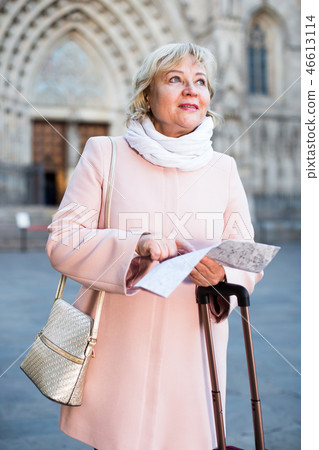 Mature woman with map and baggage Mature woman with map and baggage 46613114