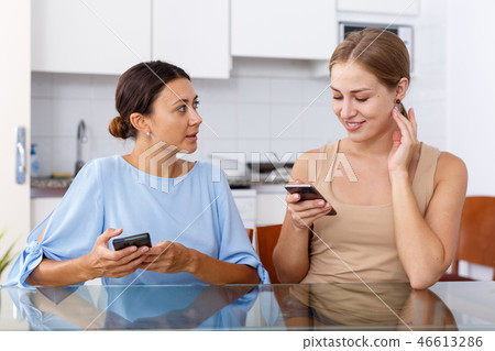 Women talking and using smartphone Women talking and using smartphone 46613286